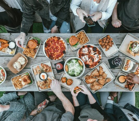 건강한 변화의 시작 식사와 운동 a group of people sitting around a table with food
