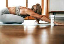 사무실에서의 스트레칭의 필요성 woman in gray sports bra and gray leggings lying on floor