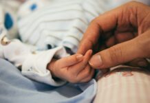 육아기 근로시간 단축 자녀 나이 ‘12세 이하’로 확대 person holding baby's index finger