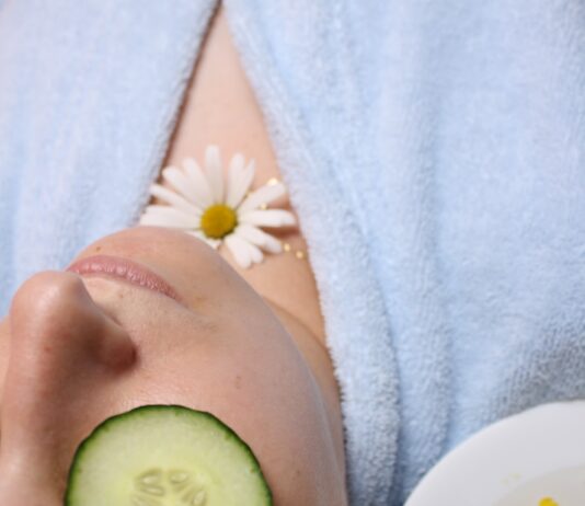 여름철 운동 후 피부 진정 팩 사용법 woman wearing blue robe lying with cucumber on eye