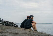 여름철 적절한 운동 시간과 빈도 woman in black tank top and black pants sitting on brown rock near body of water