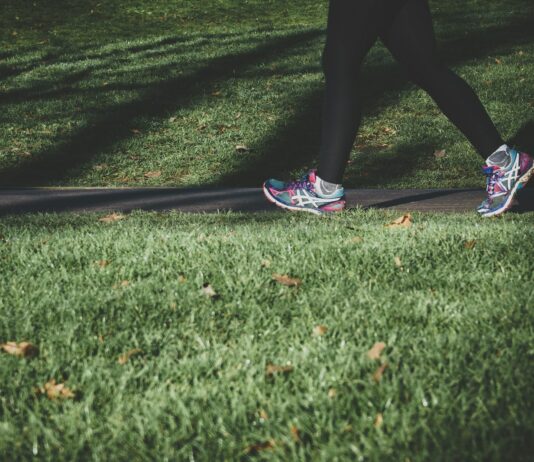 여름철 운동 중 더위 피하는 팁 shallow focus photography of person walking on road between grass
