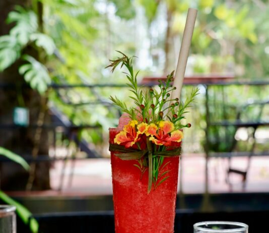여름철 운동 후 탈수 예방을 위한 음료 a tall red drink sitting on top of a wooden table