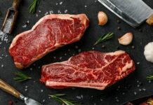 추석 앞두고 한우 할인·사료값 인하로 수급 안정 도모 two steaks on a cutting board next to garlic, garlic, and a knife