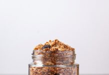 가정에서 쉽게 만드는 건강 간식 레시피 A jar filled with granola next to a wooden spoon