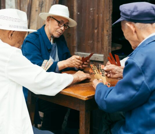치매 예방: 기억력을 증진시키는 생활 습관 a group of elderly people playing a game of cards