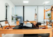 필라테스로 에너지 회복하여 만성 피로 극복하기 a woman is doing a pivot on a pivot machine