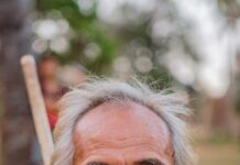 장수의 비밀: 운동과 자연식을 결합한 생활 습관 man holding brown stick smiling