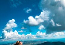 운동으로 삶을 변화시키는 신체와 정신의 조화 woman sitting on peak of mountain