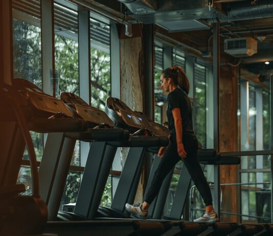 규칙적인 운동이 건강에 미치는 긍정적인 영향 a woman running on a treadmill in a gym