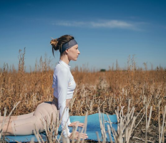 소화 건강을 개선하는 음식과 운동법 woman in white long sleeve shirt and white pants sitting on blue wooden chair during daytime