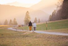 야외 활동과 운동이 주는 이점 woman in black jacket and white pants walking on road during daytime