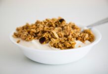 다이어트를 도와주는 슈퍼푸드, 필수 섭취 목록 a bowl of granola and yogurt with a spoon