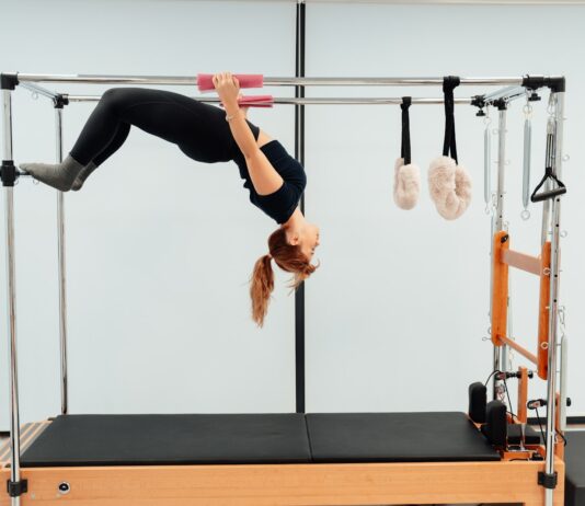 겨울철 필라테스로 유연성과 체력 키우기 a woman doing a handstand on a pivot machine