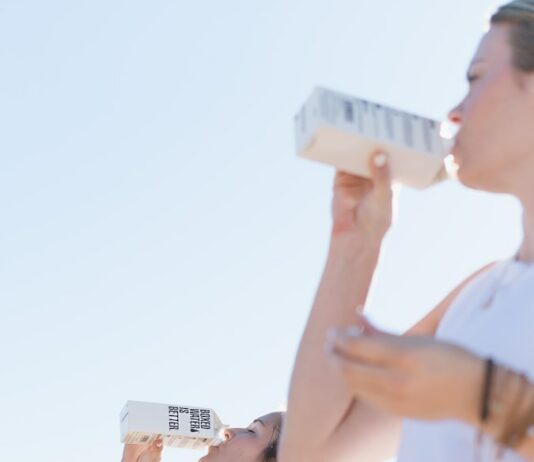 체력 관리: 적절한 수분 섭취와 운동의 중요성 Two women working out and drinking Boxed Water