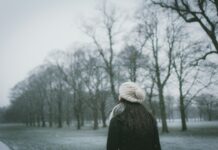 겨울철 운동으로 우울감 해소하기 woman wearing cap and black coat standing near bare tree