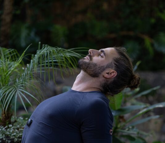 스트레스 해소와 체력 증진, 개인 맞춤형 PT의 중요성 a man sitting on a yoga mat in the middle of a forest