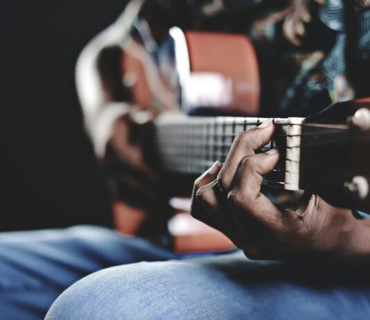건강한 취미 생활의 시작 person playing a brown guitar