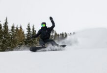 겨울철 운동으로 다이어트 성공하기 a man riding a snowboard down a snow covered slope