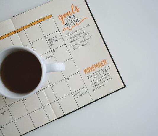 2025년, 새해의 건강 목표를 세우는 법 white ceramic mug with coffee on top of a planner