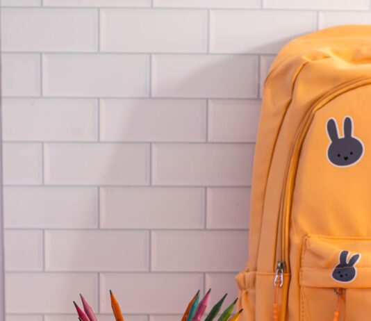 사랑의 책가방 전달식 개최 A yellow backpack sitting on top of a table