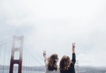 스트레스가 건강에 미치는 영향과 대처법 two women making peace sign near the Golden Gate bridge