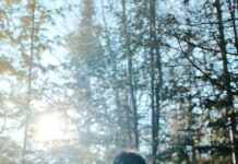 스트레스를 이겨내는 겨울 산책의 매력 person in black jacket standing in front of trees during daytime