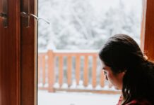 스트레스를 줄이는 겨울철 독서의 효과 woman in red and black striped long sleeve shirt and blue denim jeans sitting on brown