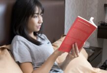 현대인을 위한 스트레스 관리 비법 woman in gray crew neck t-shirt holding orange book