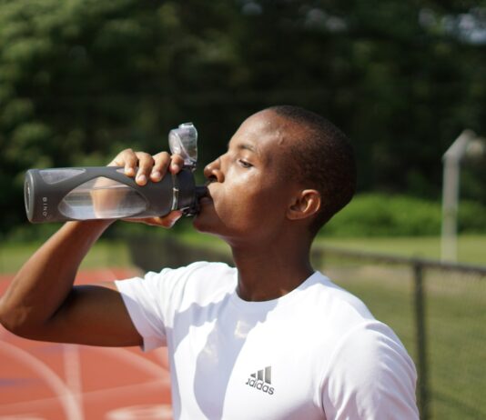 운동할 때 수분 섭취가 중요한 이유 man in white crew neck t-shirt drinking from black sports bottle