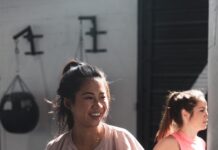 꾸준한 운동이 면역력에 미치는 영향 woman in pink long sleeve shirt and black pants holding black kettle bell