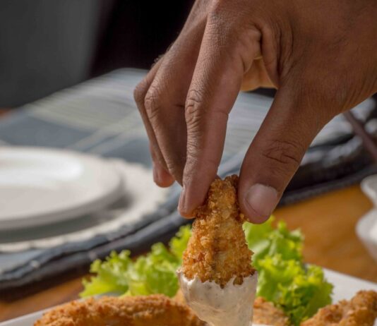 다이어트 중 외식할 때 피해야 할 음식 person dipping fried cuisine on dip