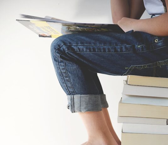 자기계발의 중요성과 꾸준한 성장의 비결 person sitting on stack of books while reading