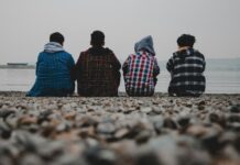 거리감 있는 친구와 친해지기 group of people sitting on white sand during daytime