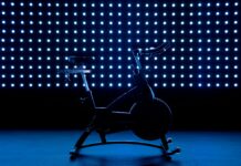 40대 이후 운동 방법: 관절 보호와 근육 유지 전략 a stationary exercise bike in front of a blue background