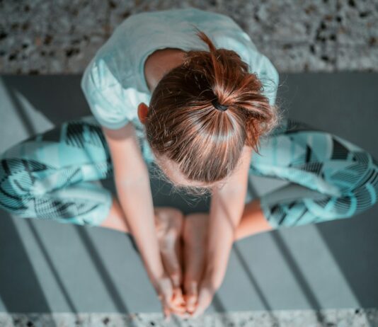 운동 후 요가 스트레칭이 중요한 이유 girl in teal t-shirt lying on white and black stripe bed