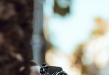 저속 노화 팁 person using black Nikon DSLR camera