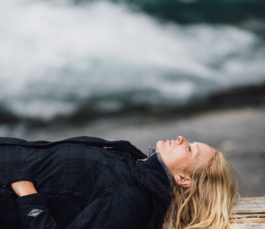 “늘 피곤한데 병원에선 이상 없다?”…만성 피로, 진짜 원인은 ‘회복 부족’ woman in black zip-up jacket leaning on large log at daytime