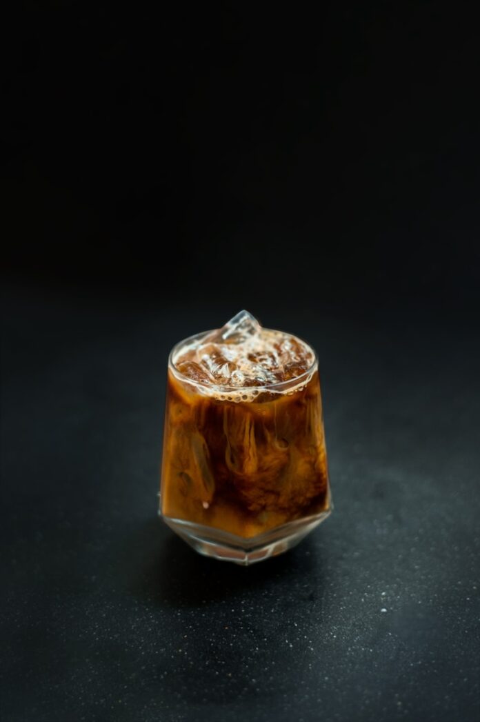 a glass filled with liquid sitting on top of a table