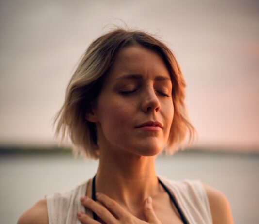 “가슴이 답답하고 숨쉬기 불편해요”… 여름 스트레스, 공황이 아닌 ‘과호흡 증후군’일 수 있습니다 woman in white vest and black bikini with hand on chest