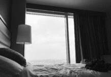 수면의 질을 높이는 5가지 생활 습관 grayscale photo of bed near white table lamp