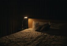 깊은 수면이 건강을 좌우한다 – 현대인을 위한 숙면 가이드 table lamp turned-on near bed