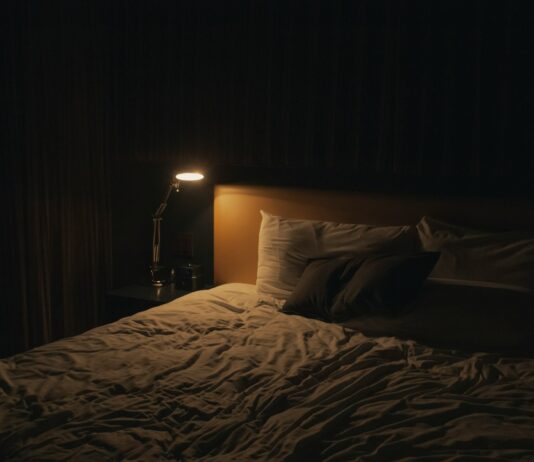 깊은 수면이 건강을 좌우한다 – 현대인을 위한 숙면 가이드 table lamp turned-on near bed