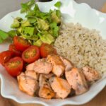 건강한 식단, 행복한 삶의 첫걸음 a white bowl filled with chicken, rice, tomatoes and avocado