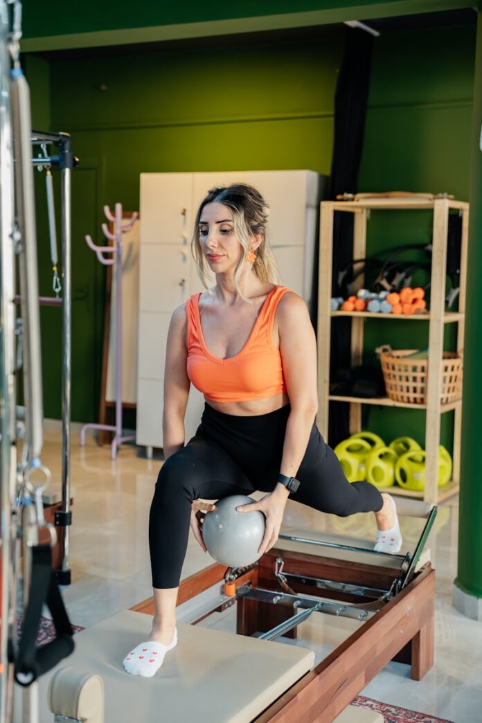 Woman does pilates exercise with a ball.