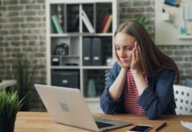 만성피로, 현대인의 고질병…지속되는 피로에 숨겨진 원인과 극복 방법 a woman sitting at a table with a laptop in front of her