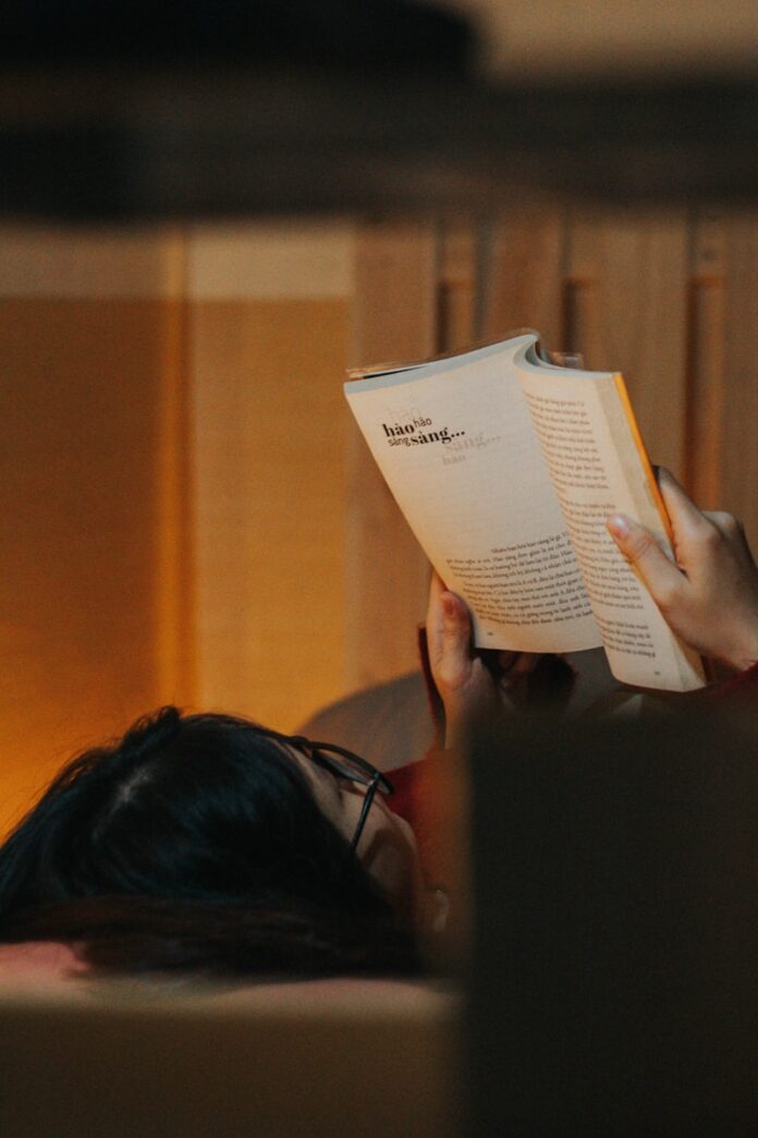 woman in black tank top reading book