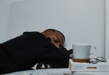 만성피로, 단순한 피로를 넘어 삶의 질을 떨어뜨린다 a man sleeping on a bed next to a stack of books
