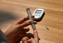 “요즘 이유 없이 짜증나요”… 혹시 혈당이 불안정한 건 아닐까요? a person holding a pen and a cell phone on a table