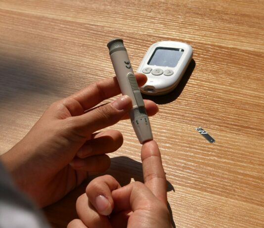 “요즘 이유 없이 짜증나요”… 혹시 혈당이 불안정한 건 아닐까요? a person holding a pen and a cell phone on a table